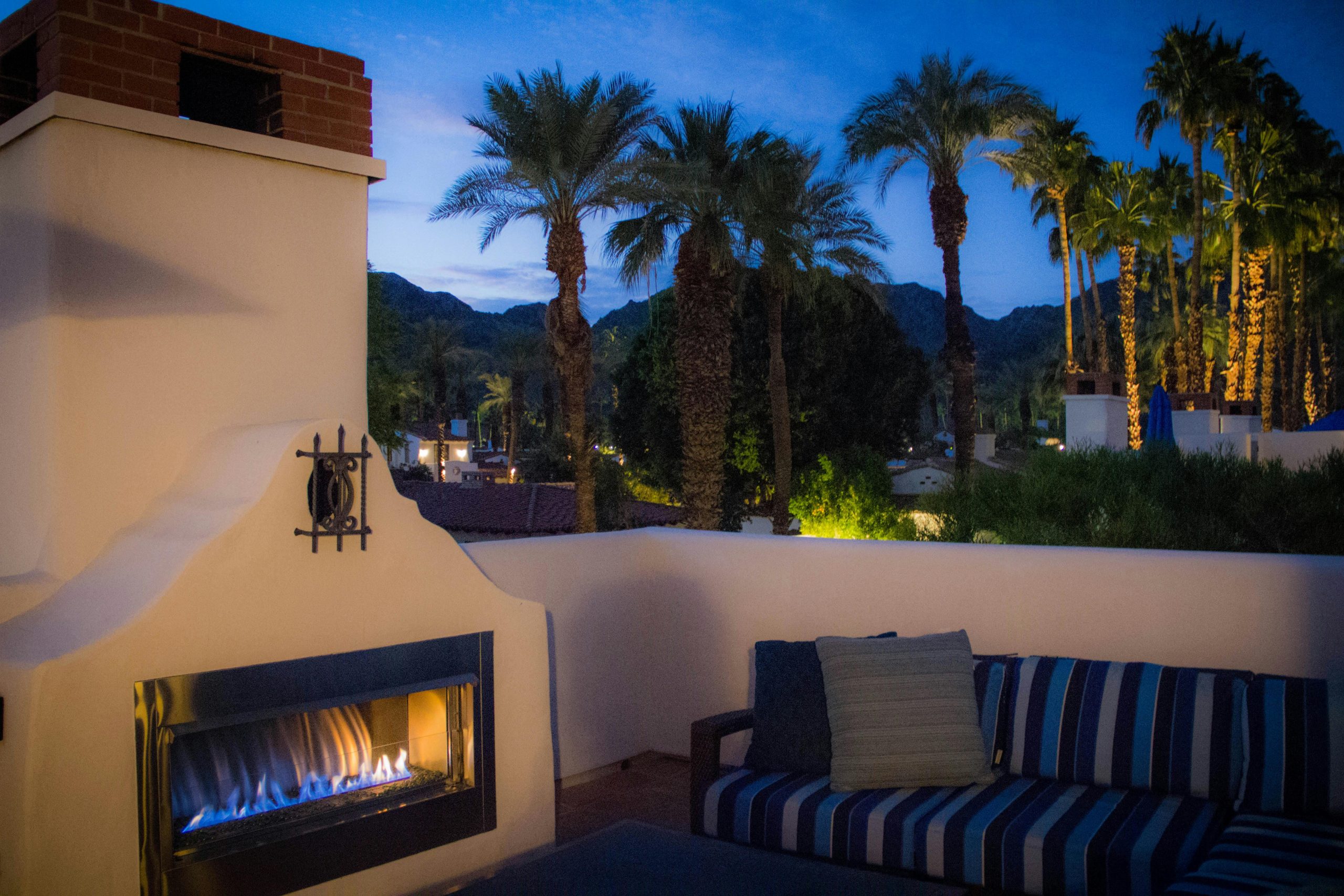 Experience tropical relaxation by the fireplace at a luxury resort in La Quinta, CA.