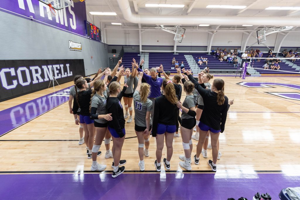The Cornell volleyball team huddles around Jeff Meeker at the end of a timeout.